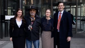 Uncle Dennis who filed legal challenge to access age pension earlier, standing with legal team.
